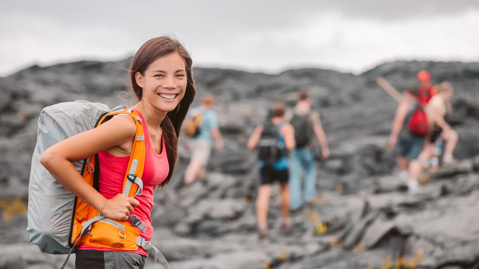A small guided group walking across a hardened lava field in Hawaii Volcanoes National Park