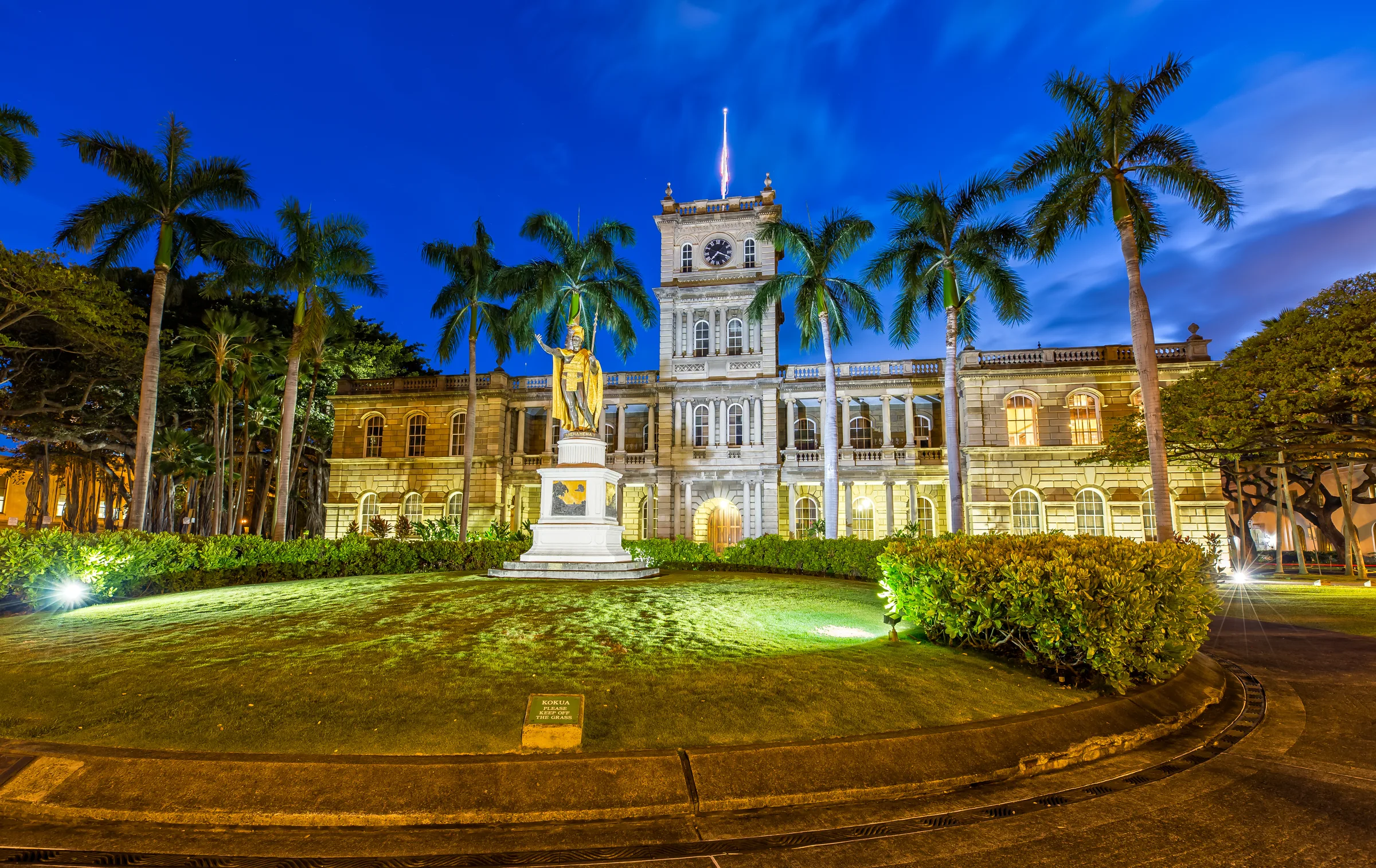 King Kamehameha statue lit at dusk in front of Aliiolani Hale